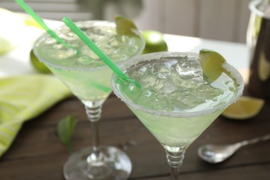 Delicious Margarita cocktail in glasses on table, closeup