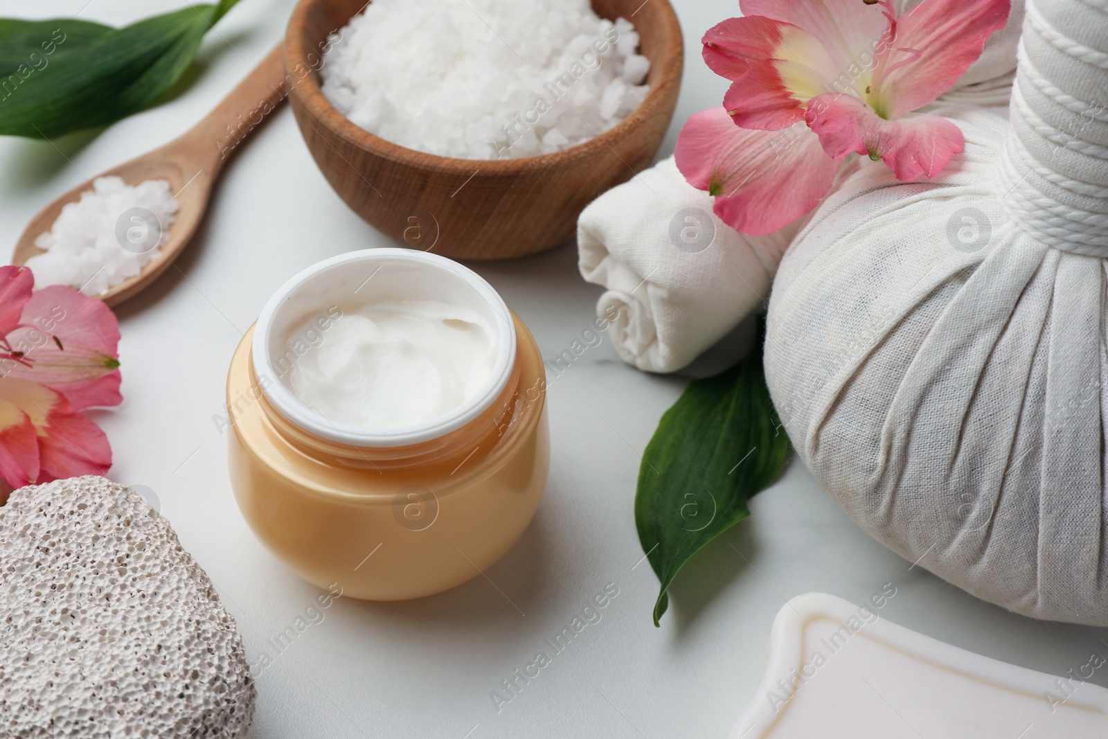 Photo of Beautiful composition with spa products and flowers on white marble table, closeup