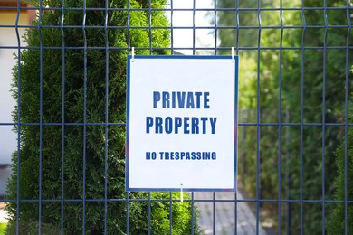 Image of Sign with text Private Property No Trespassing on fence