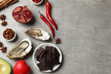 Natural aphrodisiac. Different food products and heart model on grey table, flat lay. Space for text