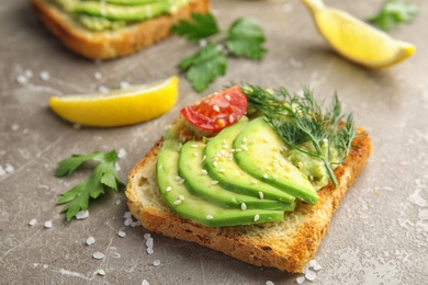 Photo of Crisp toast with sliced avocado on table, closeup