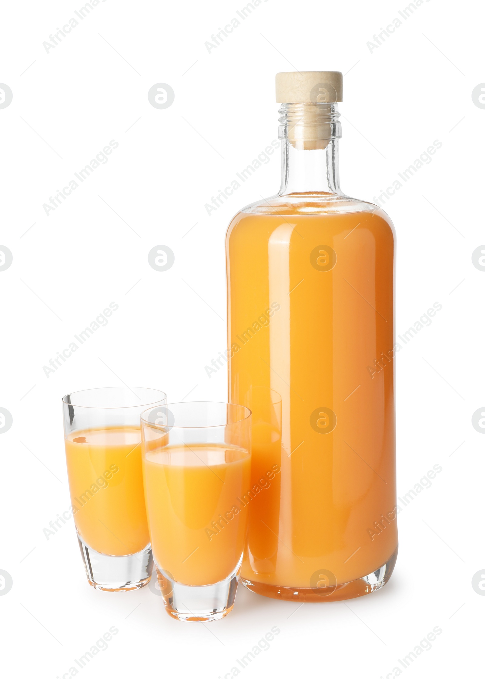 Photo of Bottle and shot glasses with tasty tangerine liqueur isolated on white