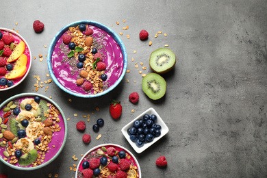 Image of Delicious acai smoothie with toppings in bowls on table, flat lay. Space for text