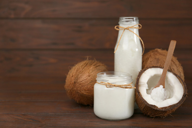 Composition with organic coconut oil on wooden table, space for text. Healthy cooking