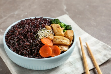 Photo of Plate of boiled brown rice with meat served on table, closeup. Space for text