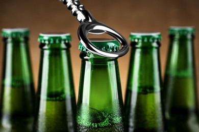 Opening bottle of beer on brown background, closeup
