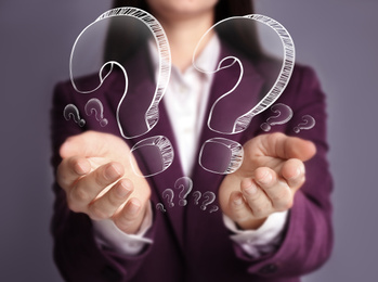 Image of Businesswoman on grey background demonstrating drawings of question mark