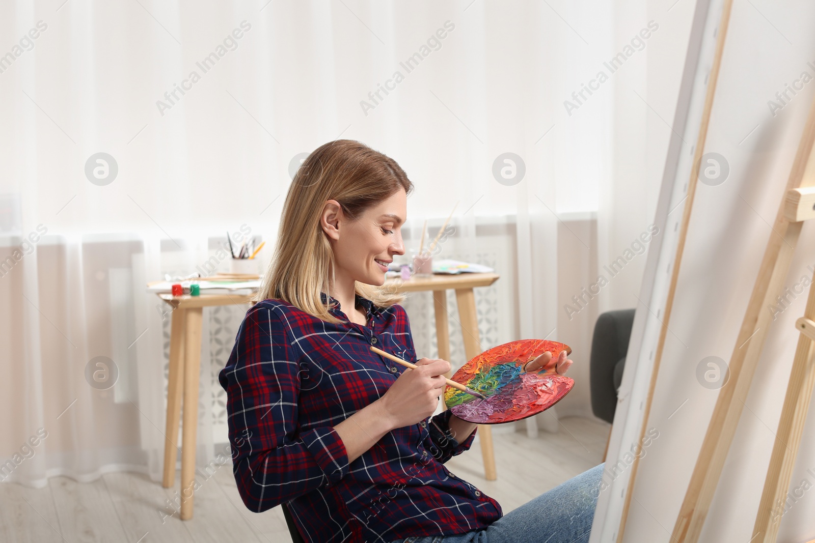 Photo of Beautiful woman painting in studio. Creative hobby