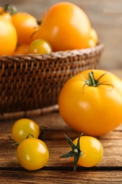 Photo of Ripe yellow tomatoes on wooden table, closeup