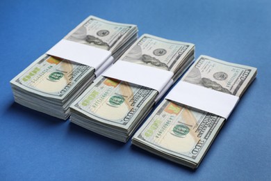 Many dollar banknotes on blue background. American national currency