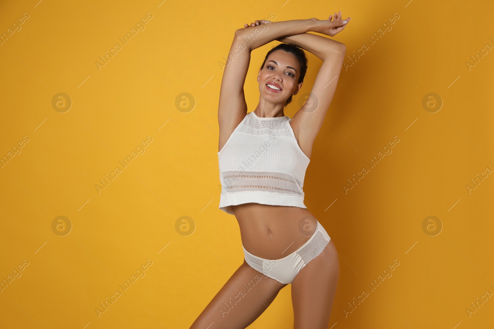 Photo of Beautiful woman in white sexy panties on yellow background, space for text