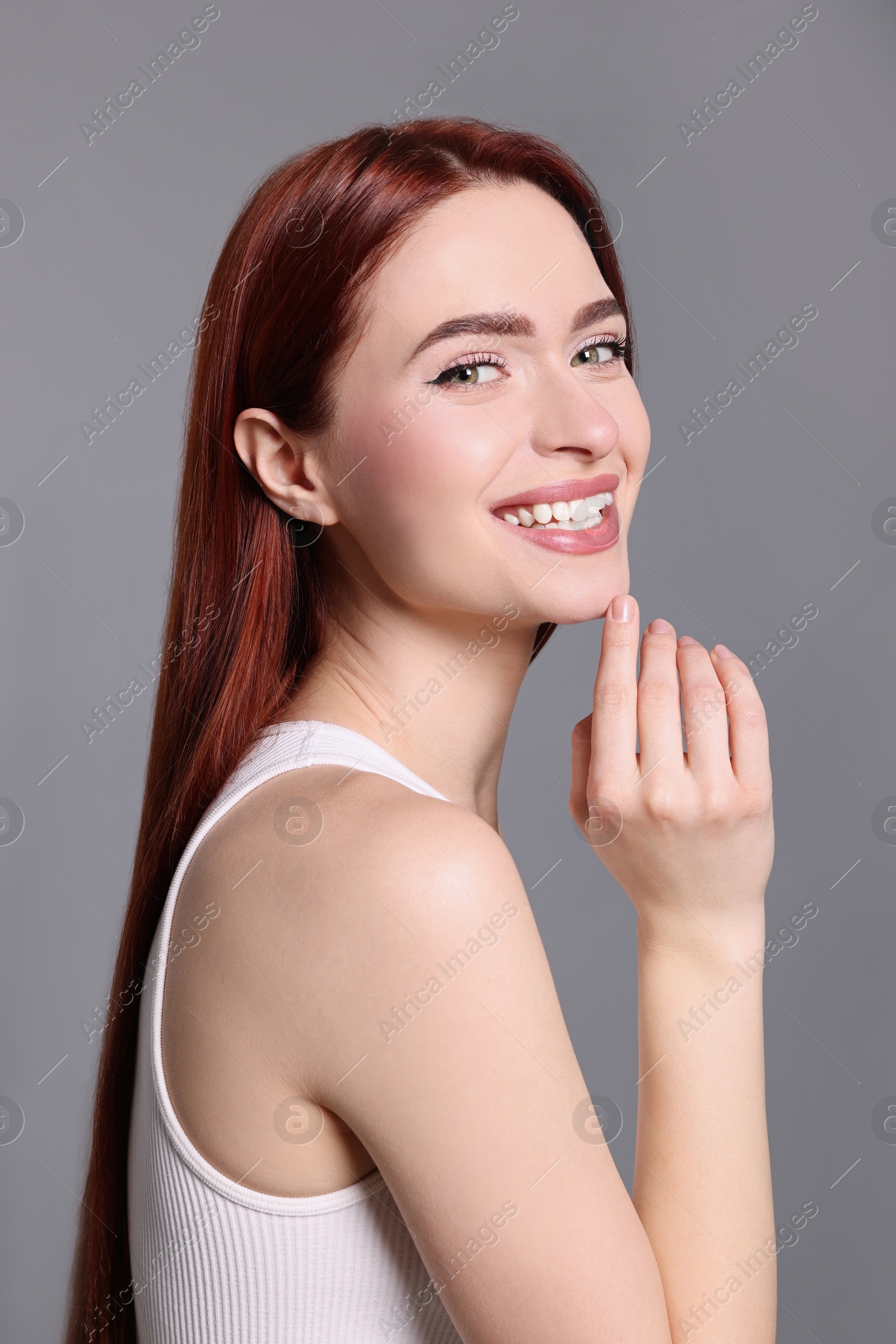 Photo of Happy woman with red dyed hair on light gray background