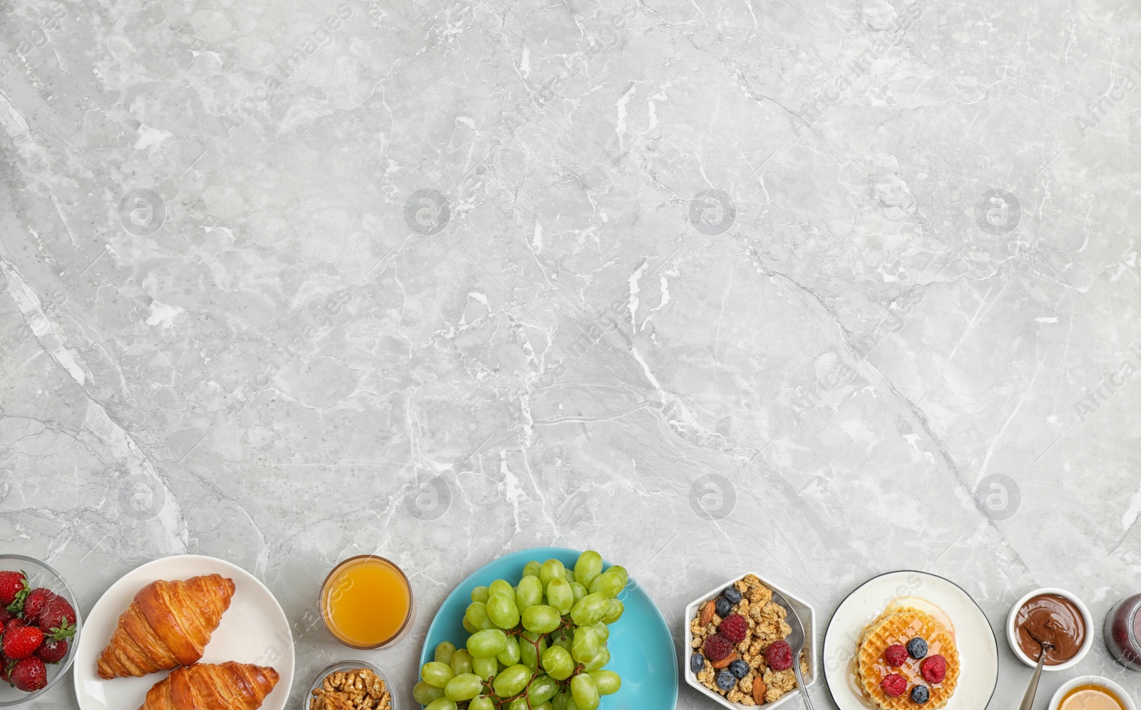 Photo of Delicious breakfast served on light grey marble table, flat lay. Space for text