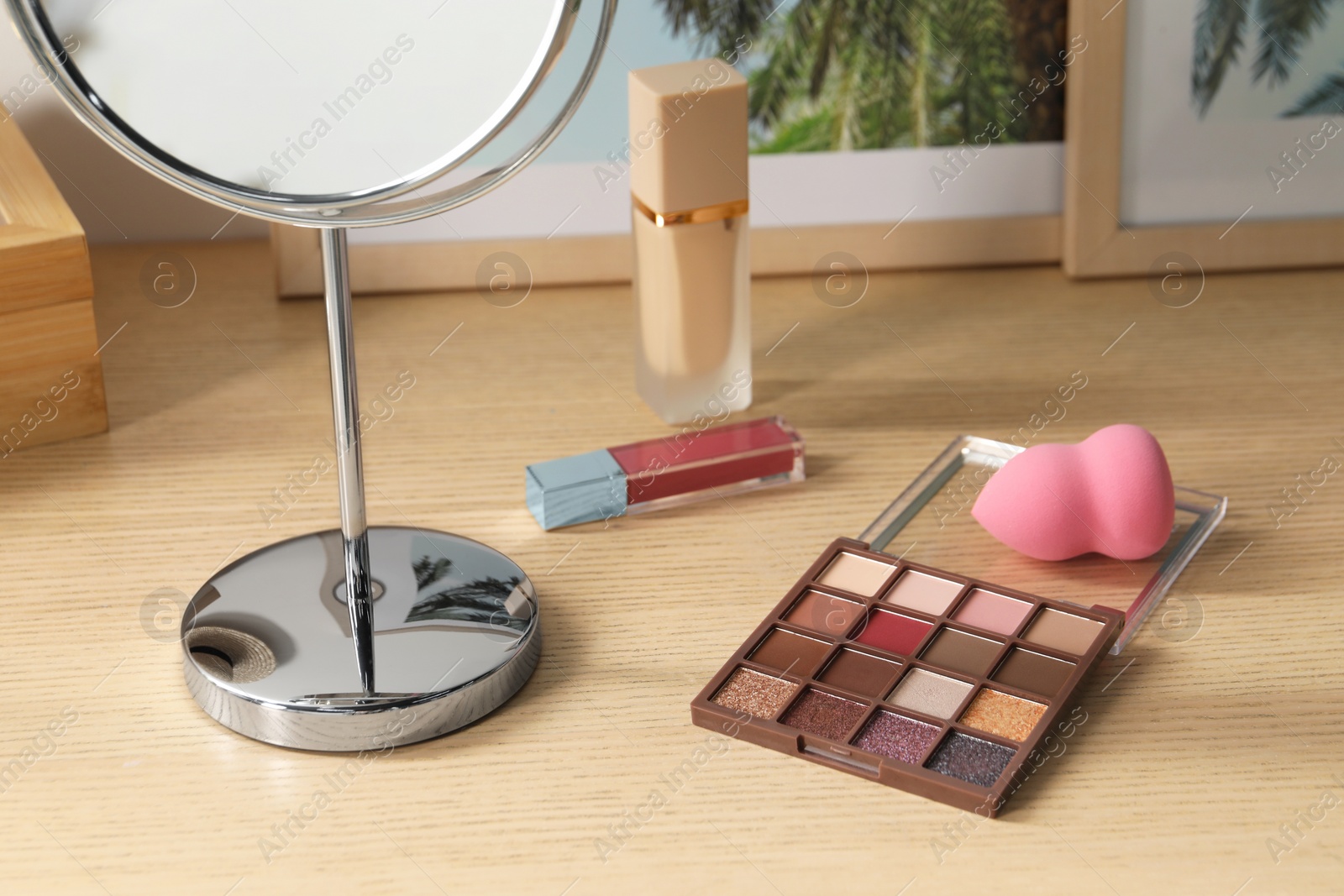 Photo of Mirror and makeup products on wooden dressing table