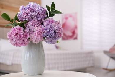 Bouquet of beautiful hydrangea flowers on table in bedroom, space for text. Interior design
