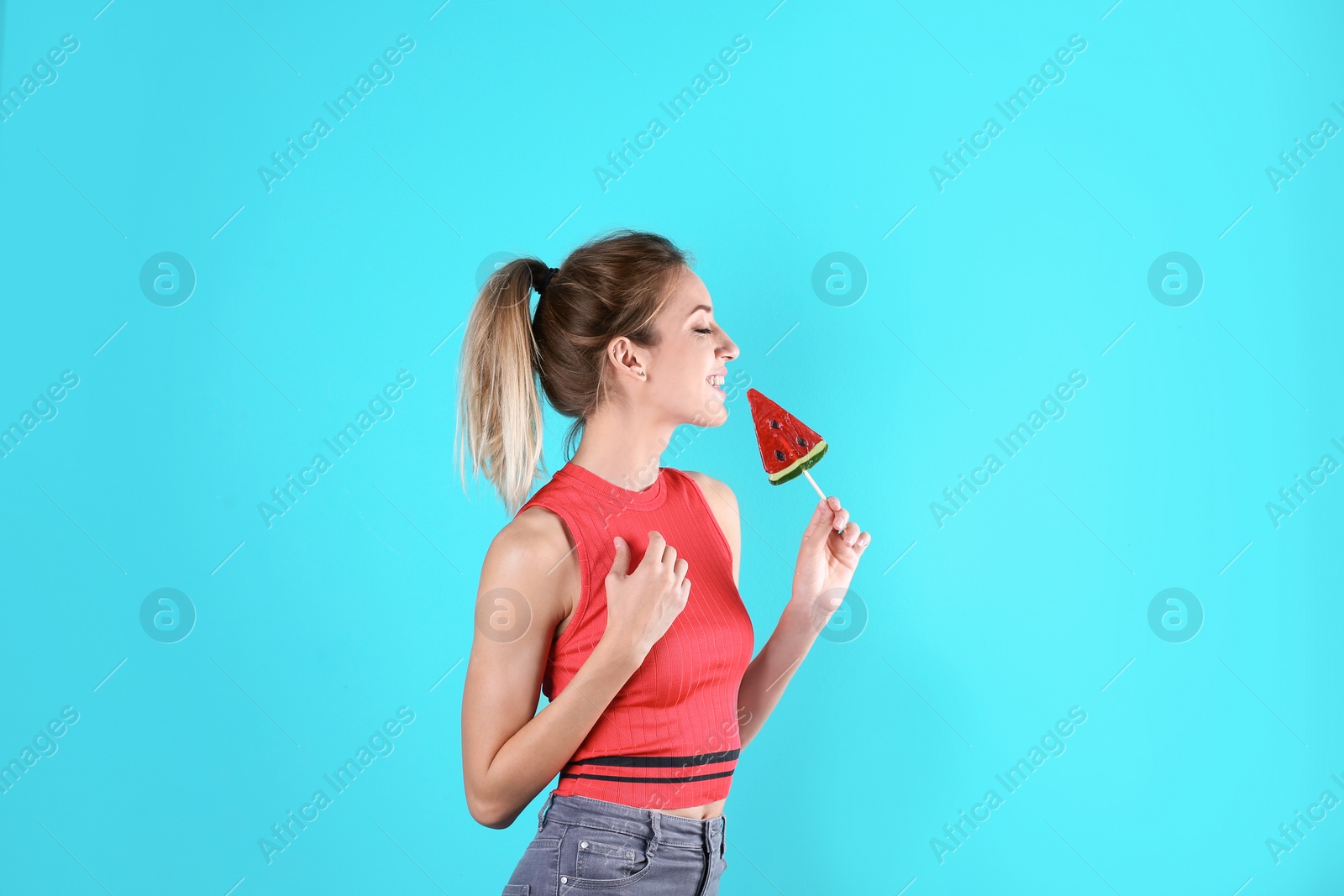 Photo of Young pretty woman with candy on colorful background