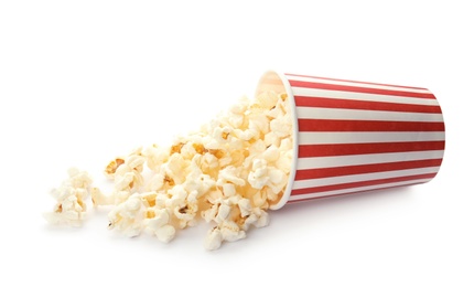 Overturned cup with delicious fresh popcorn on white background