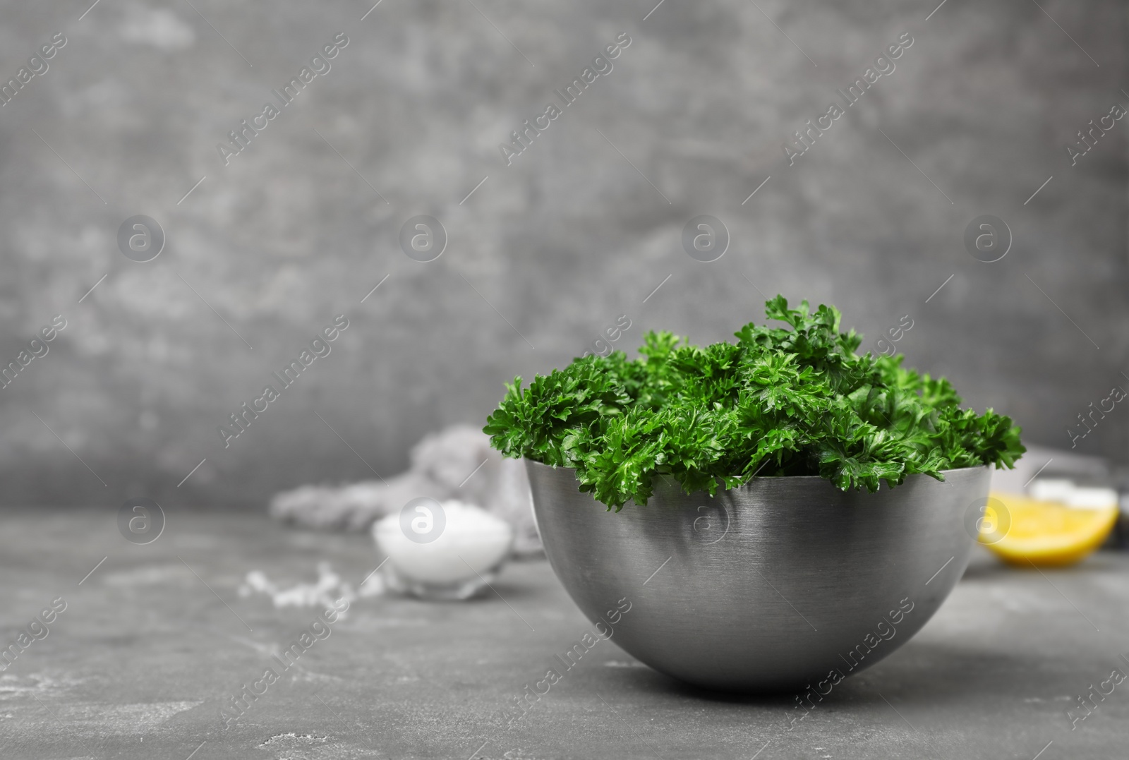 Photo of Bowl with fresh green parsley on table