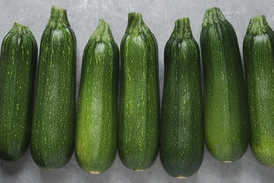 Raw ripe zucchinis on light grey table, flat lay