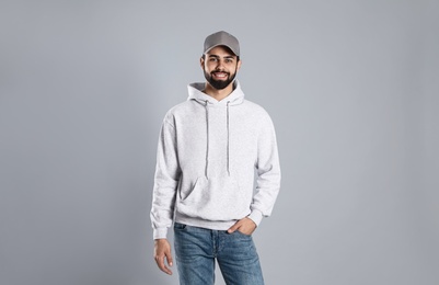 Portrait of young man in sweater on grey background. Mock up for design