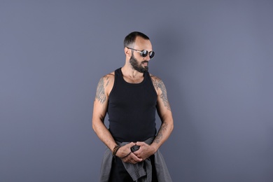 Photo of Portrait of handsome tattooed man on grey background