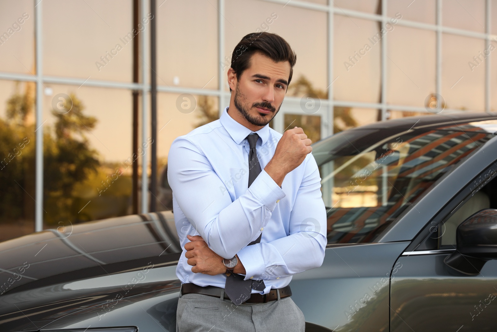 Photo of Attractive young man near luxury car outdoors