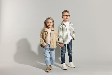 Photo of Fashion concept. Stylish children posing on light grey background