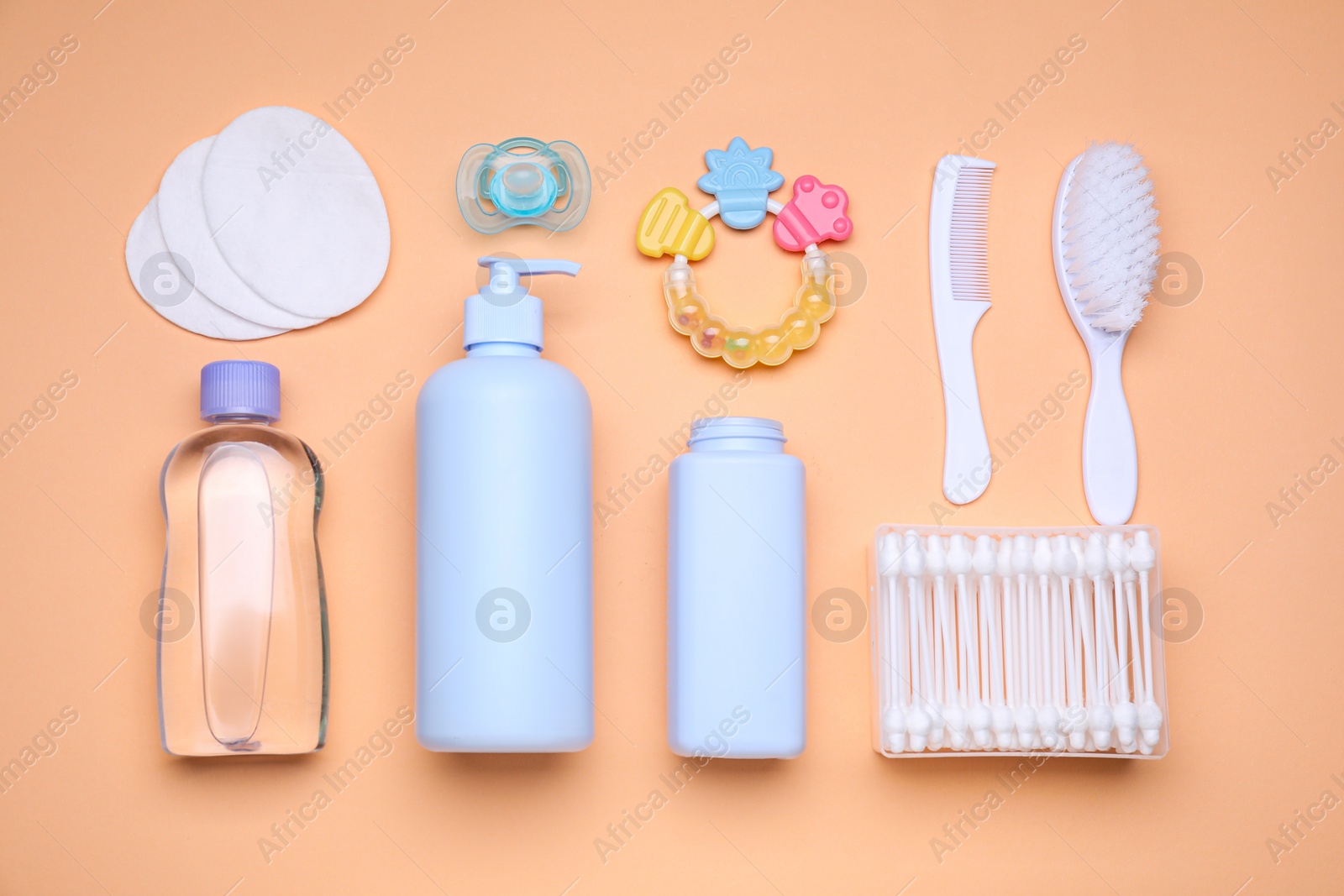 Photo of Flat lay composition with baby care products and accessories on pale orange background