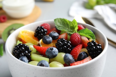 Photo of Fresh tasty fruit salad on grey table, closeup