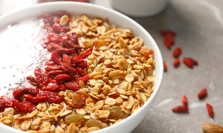 Photo of Smoothie bowl with goji berries on beige marble table, closeup