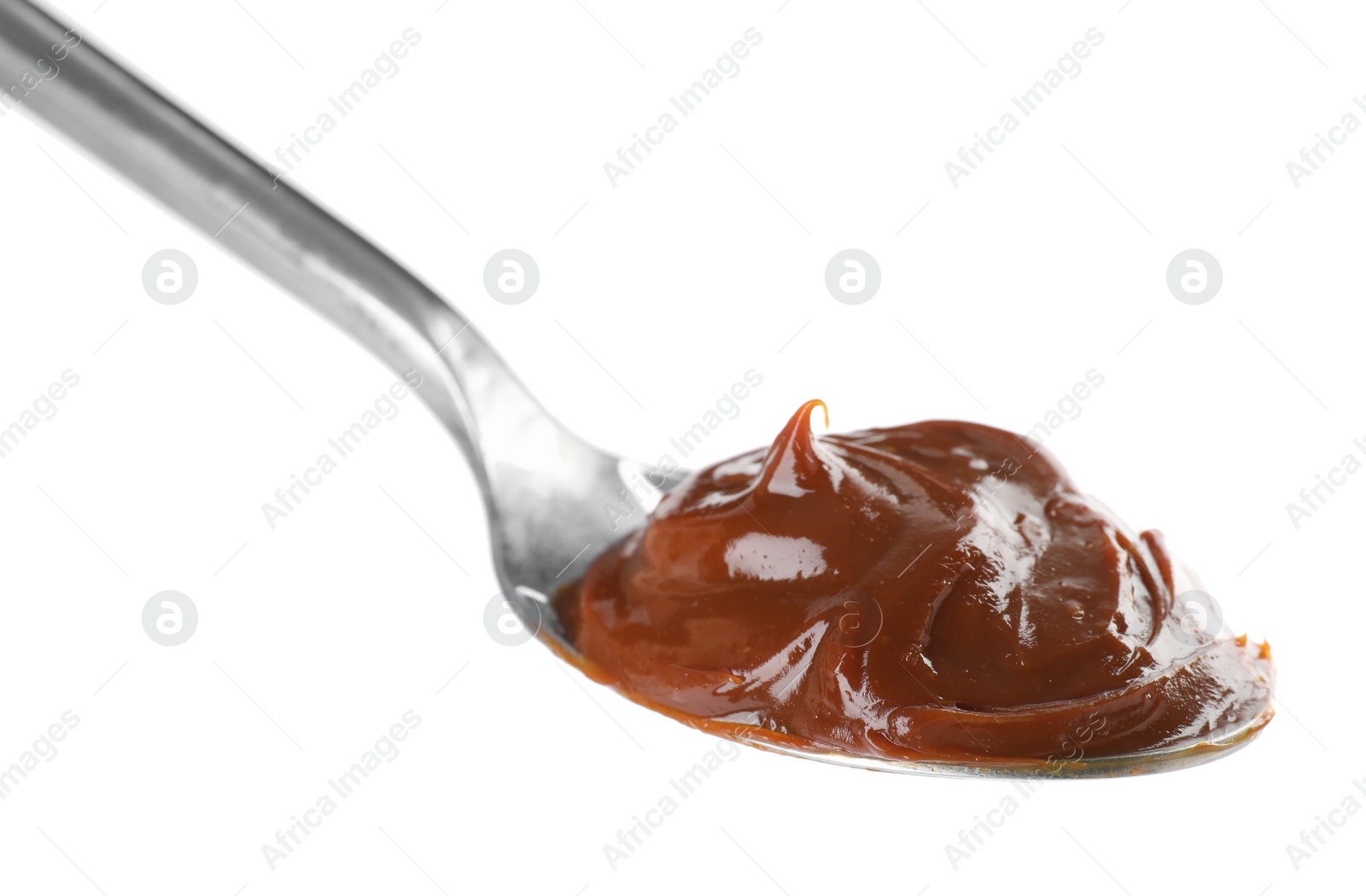 Photo of Spoon with tasty boiled condensed milk isolated on white