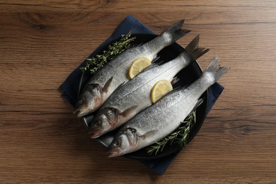 Photo of Tasty sea bass fish on wooden table, top view