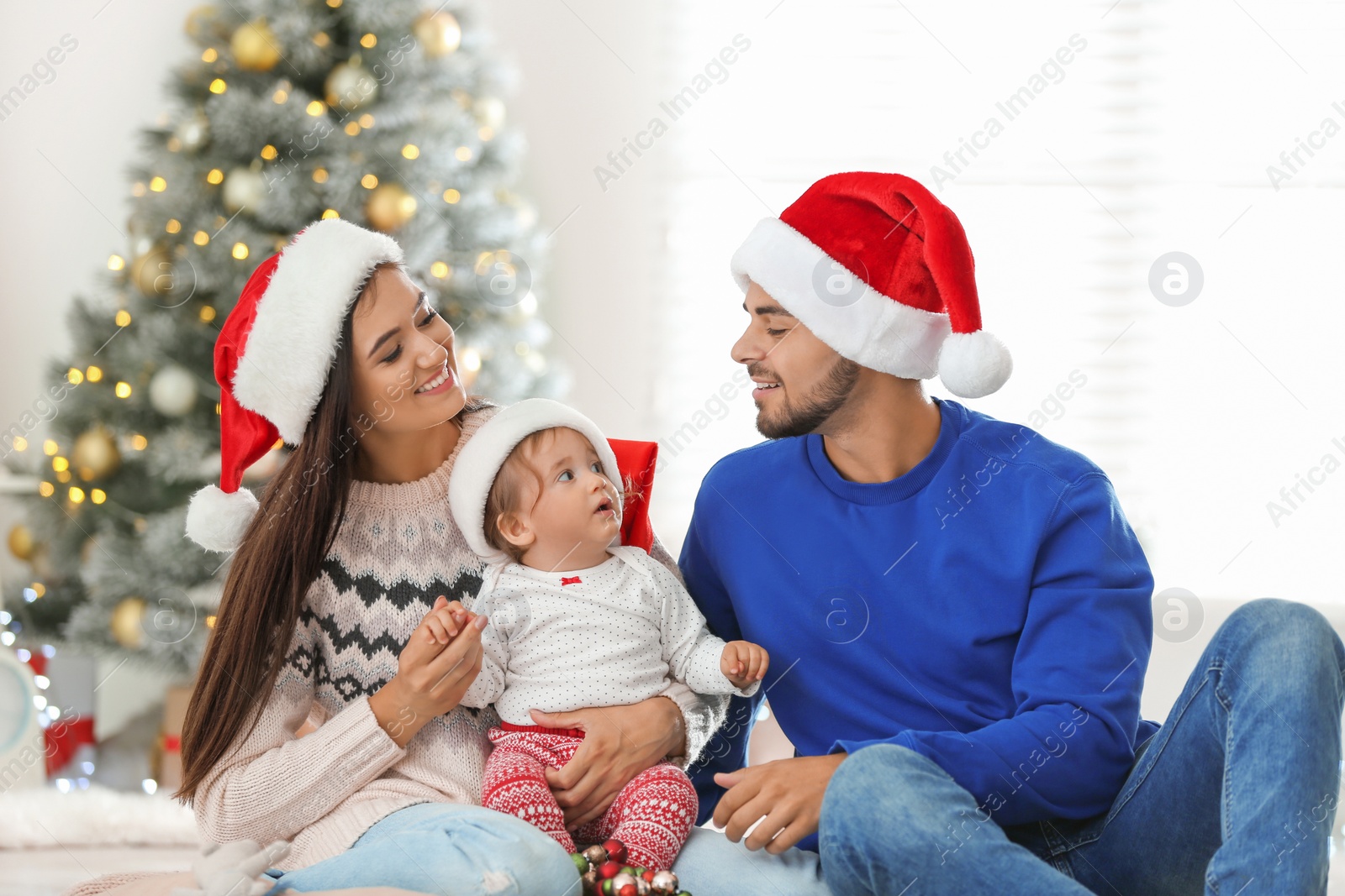 Photo of Happy family with cute baby at home. Christmas celebration