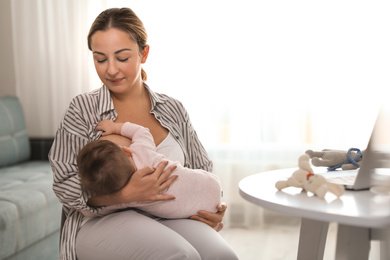 Young woman breastfeeding her baby at home