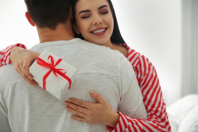 Lovely couple with gift box at home, closeup. Valentine's day celebration
