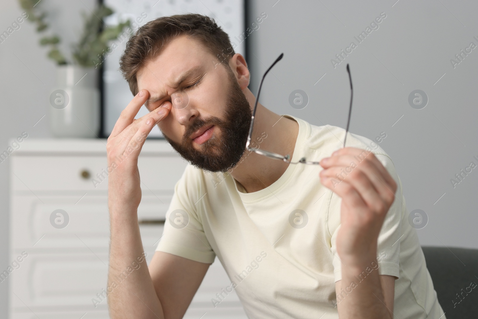 Photo of Overwhelmed man with glasses suffering at home