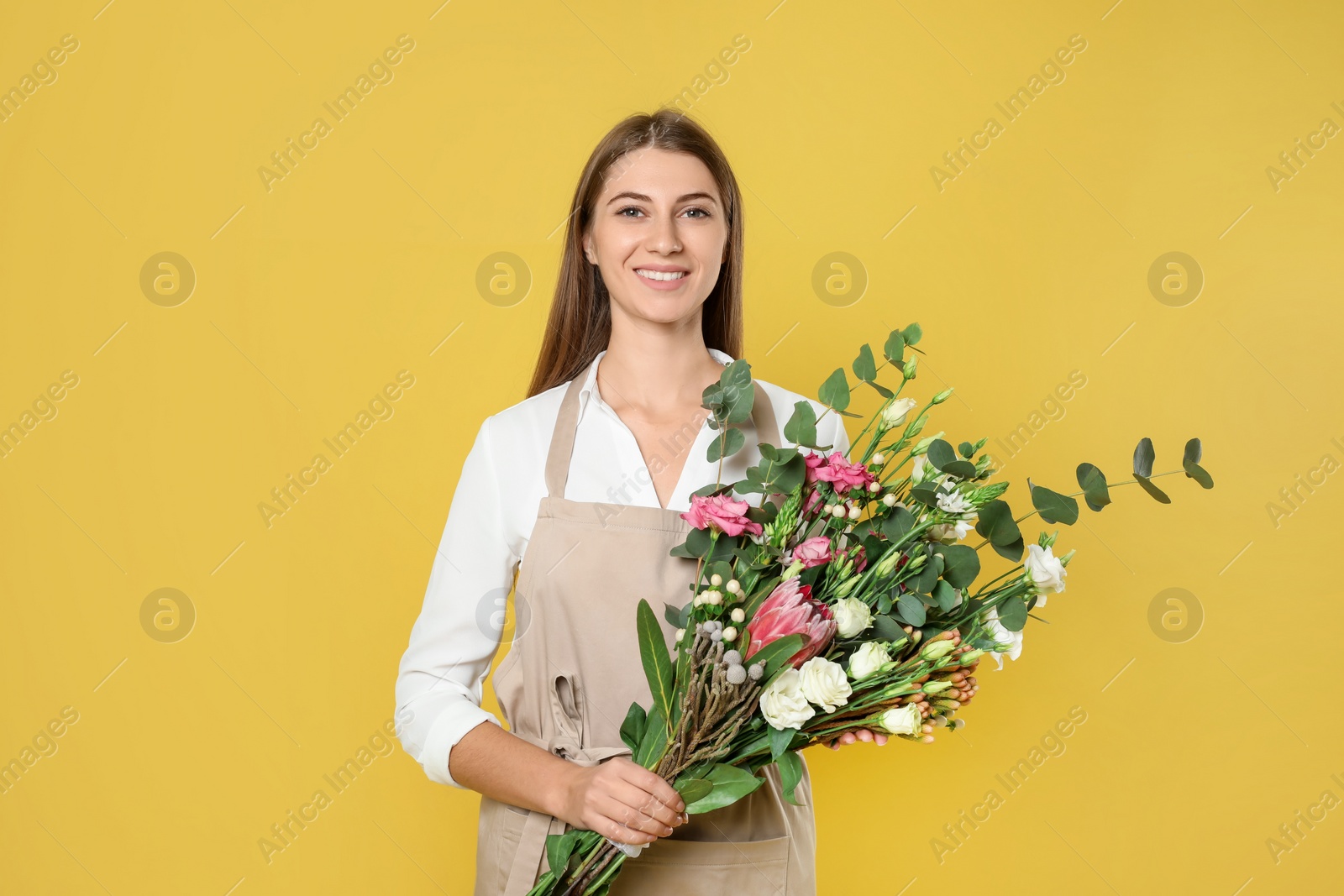 Photo of Florist with beautiful bouquet on yellow background