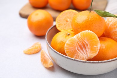 Photo of Fresh juicy tangerines on light grey table, closeup. Space for text