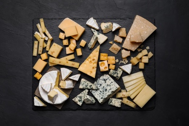 Photo of Cheese plate on black table, top view