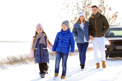Happy family walking in countryside on winter day