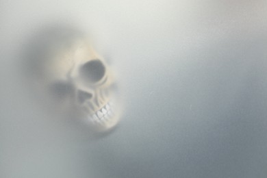 Photo of Silhouette of creepy ghost with skull behind cloth, space for text