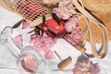 Photo of Flat lay composition with beautiful peonies and rose wine on white fabric