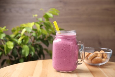 Tasty milk shake on wooden table indoors