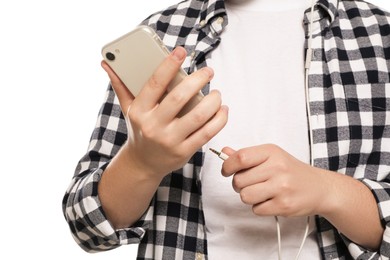 Photo of Man plugging headphones to smartphone on white background, closeup