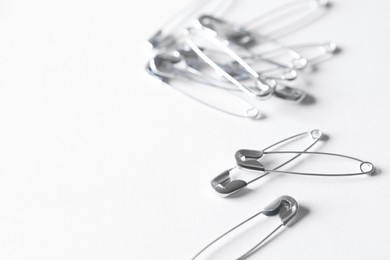 Many safety pins on white background, space for text