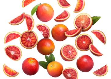 Image of Many tasty Sicilian oranges and green leaves falling on white background