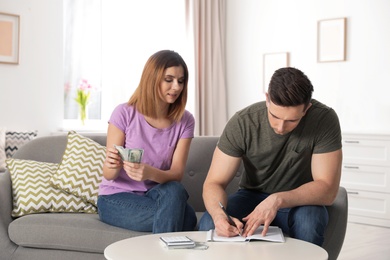 Couple managing budget to save money in living room