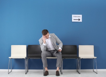 Photo of Young man waiting for job interview, indoors