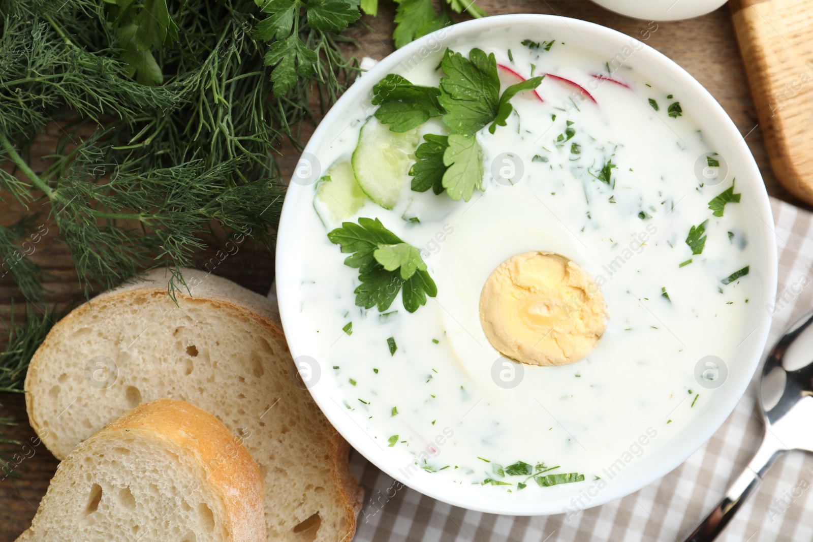 Photo of Delicious cold summer soup with kefir served on wooden table, flat lay