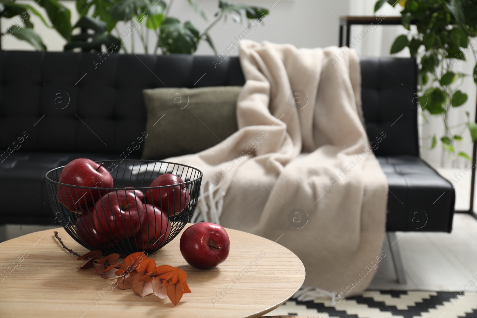 Photo of Red apples and dry eucalyptus branch on side table in room, space for text